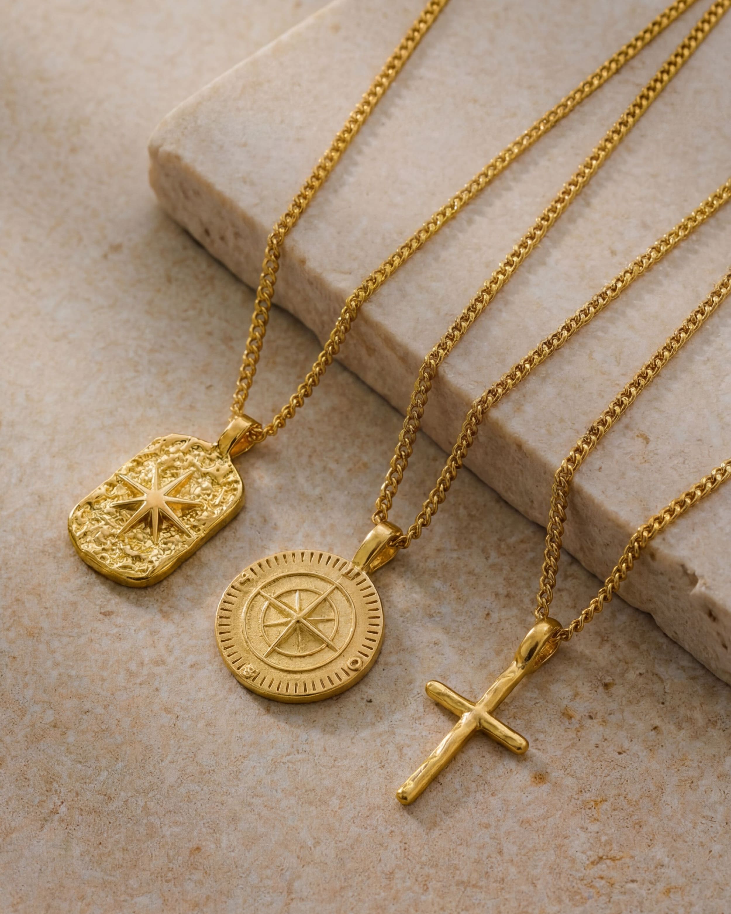 NORTHWALK GOLD NECKLACE gold chain with a circular compass pendant on a warm beige background