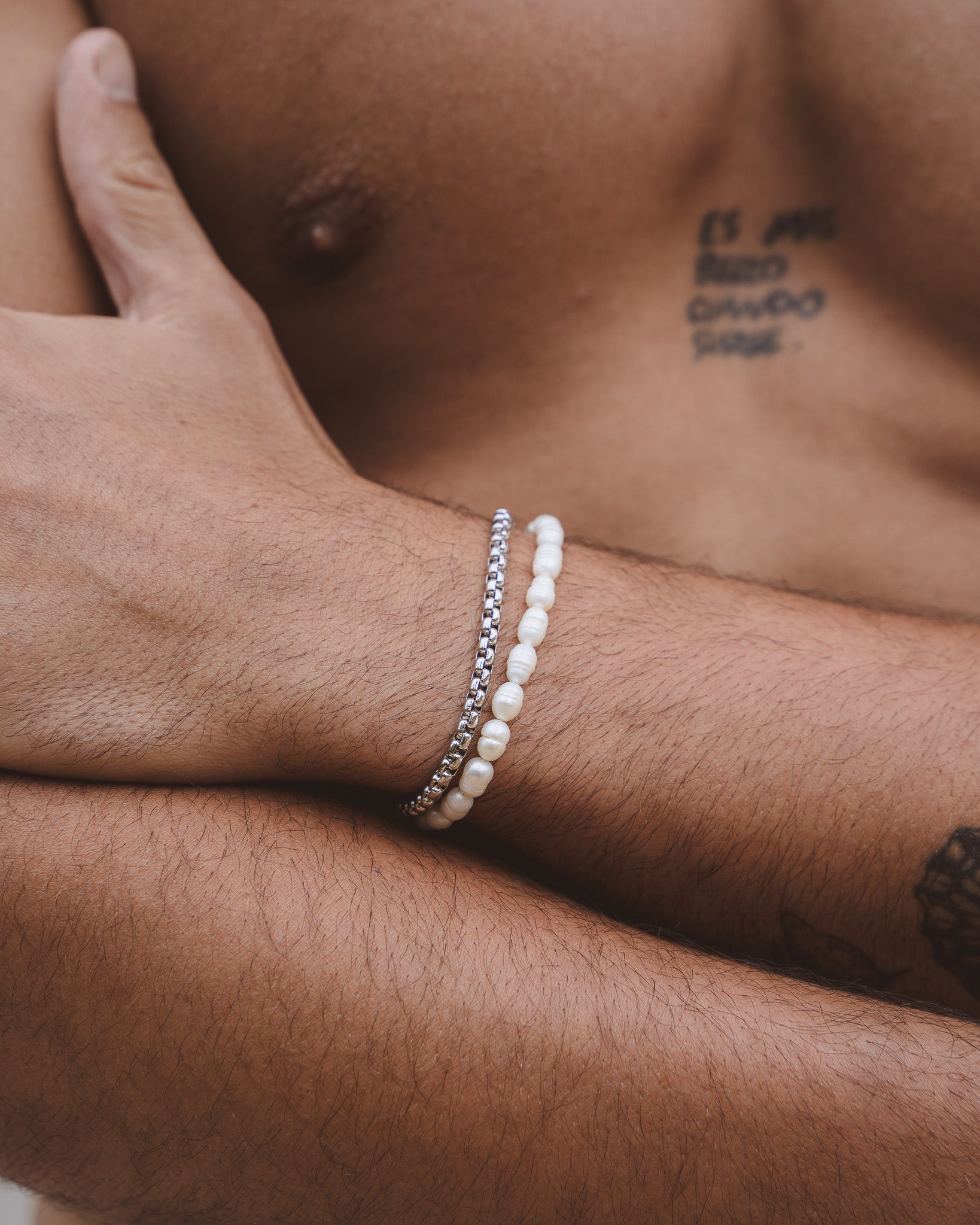 Belize Pearl Bracelet with Caribbean freshwater pearls on a wrist beside a silver chain bracelet