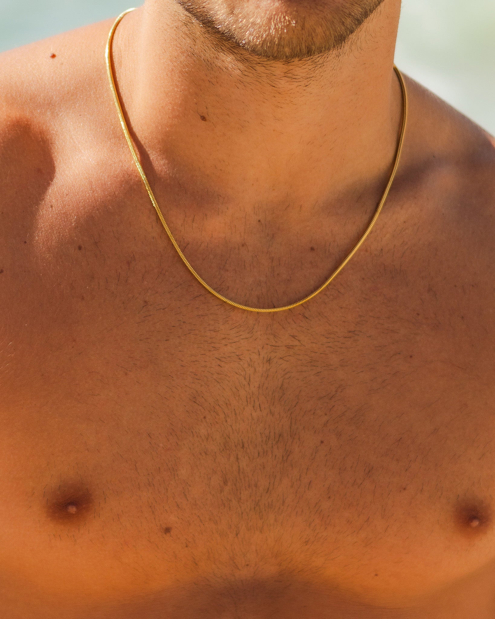 Sunset Gold Chain resting on a sunlit chest across the collarbone