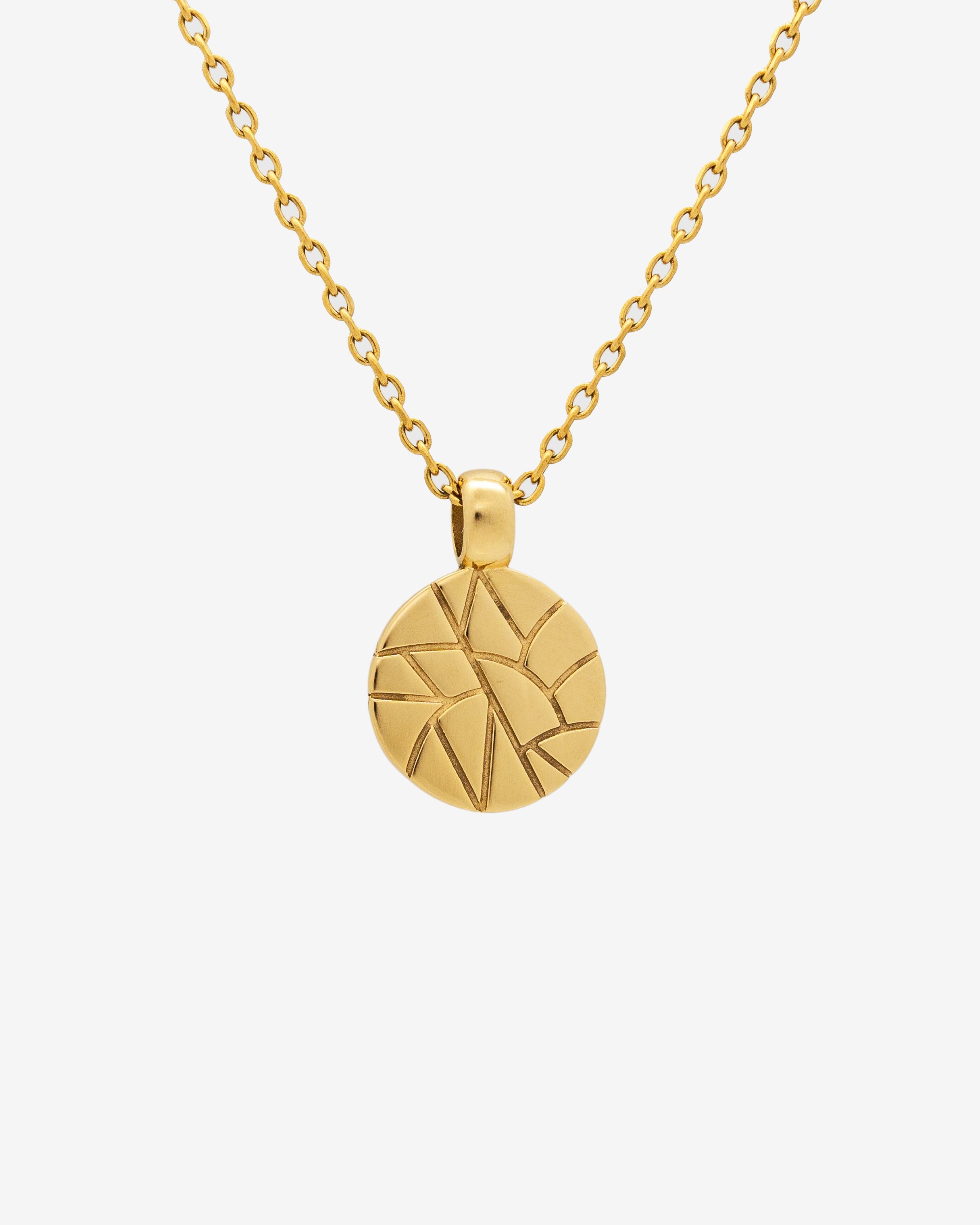 Broken gold necklace with a circular pendant carved with abstract geometric lines