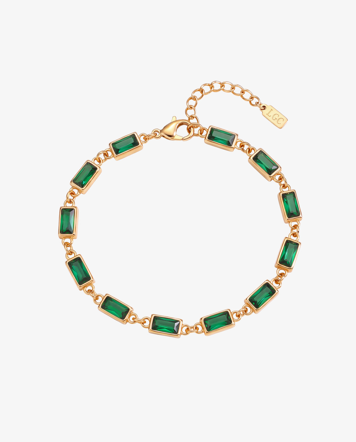 Gold bracelet with emerald green rectangular stones linked in a gold chain against a white background