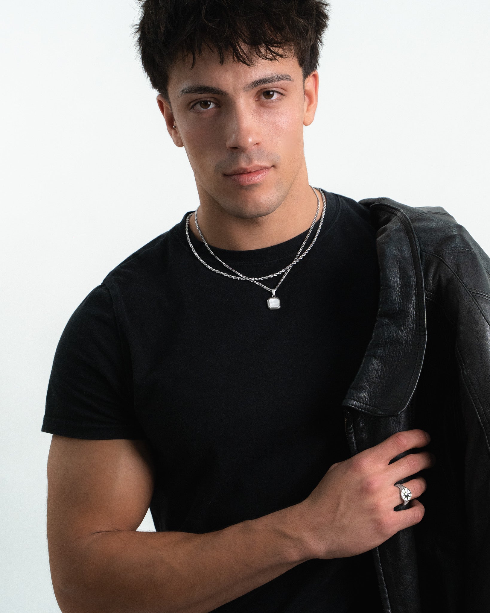 Model wearing NOVA SILVER NECKLACE with layered chains and a hexagonal pale stone pendant