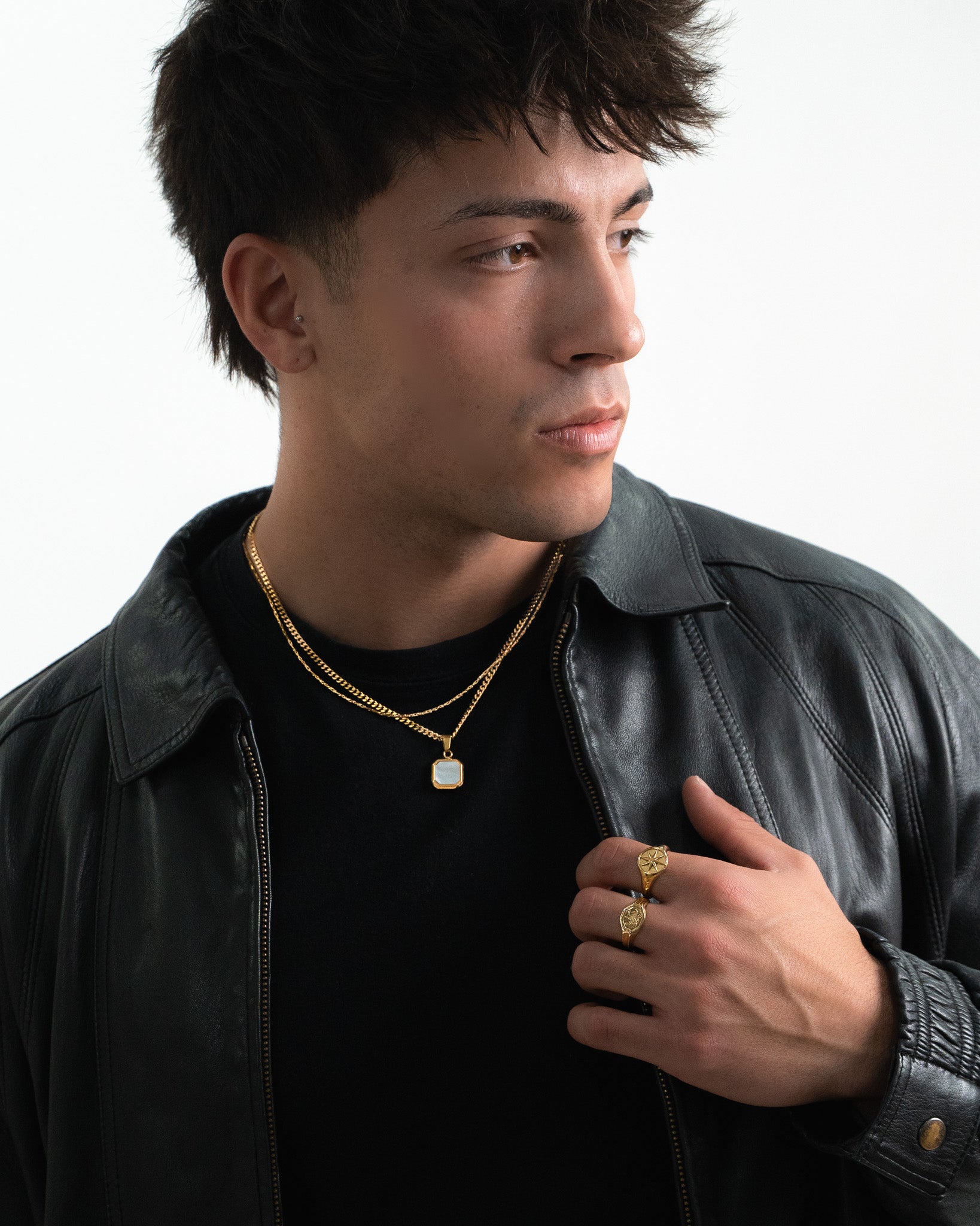 Man wearing Legacy Gold Ring on the finger with layered gold chains and a pendant