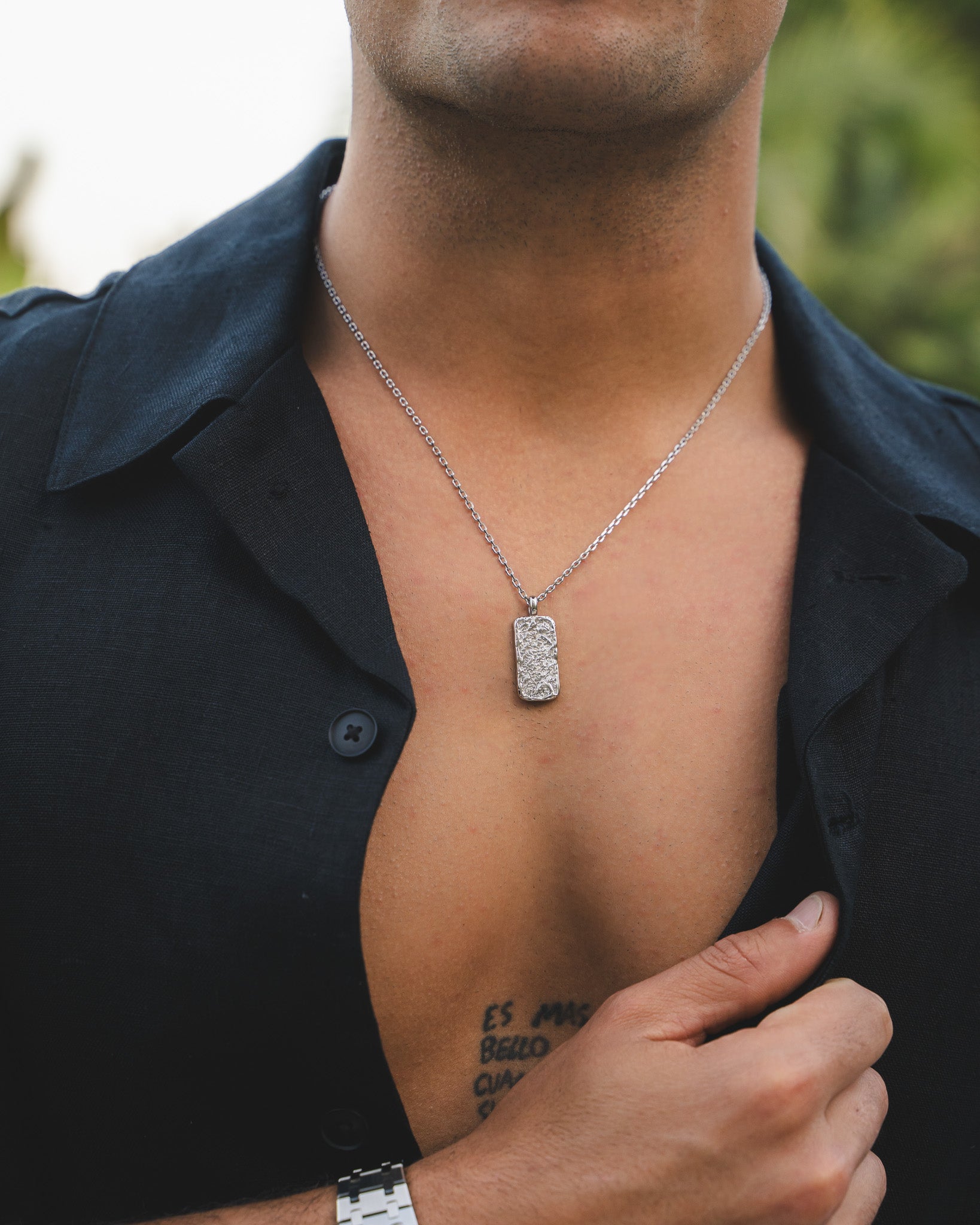 Close up of a man wearing a Moonrock Silver Necklace with a rectangular textured pendant