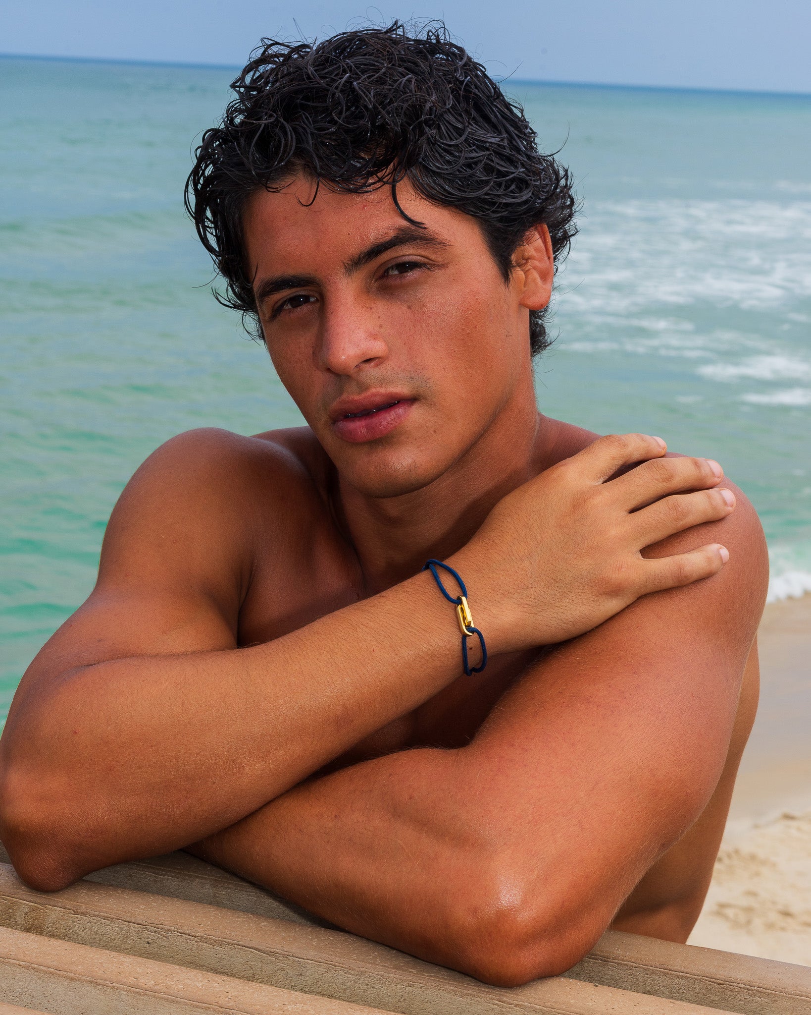 Man on the beach wearing Atlantis Gold Bracelet on his wrist
