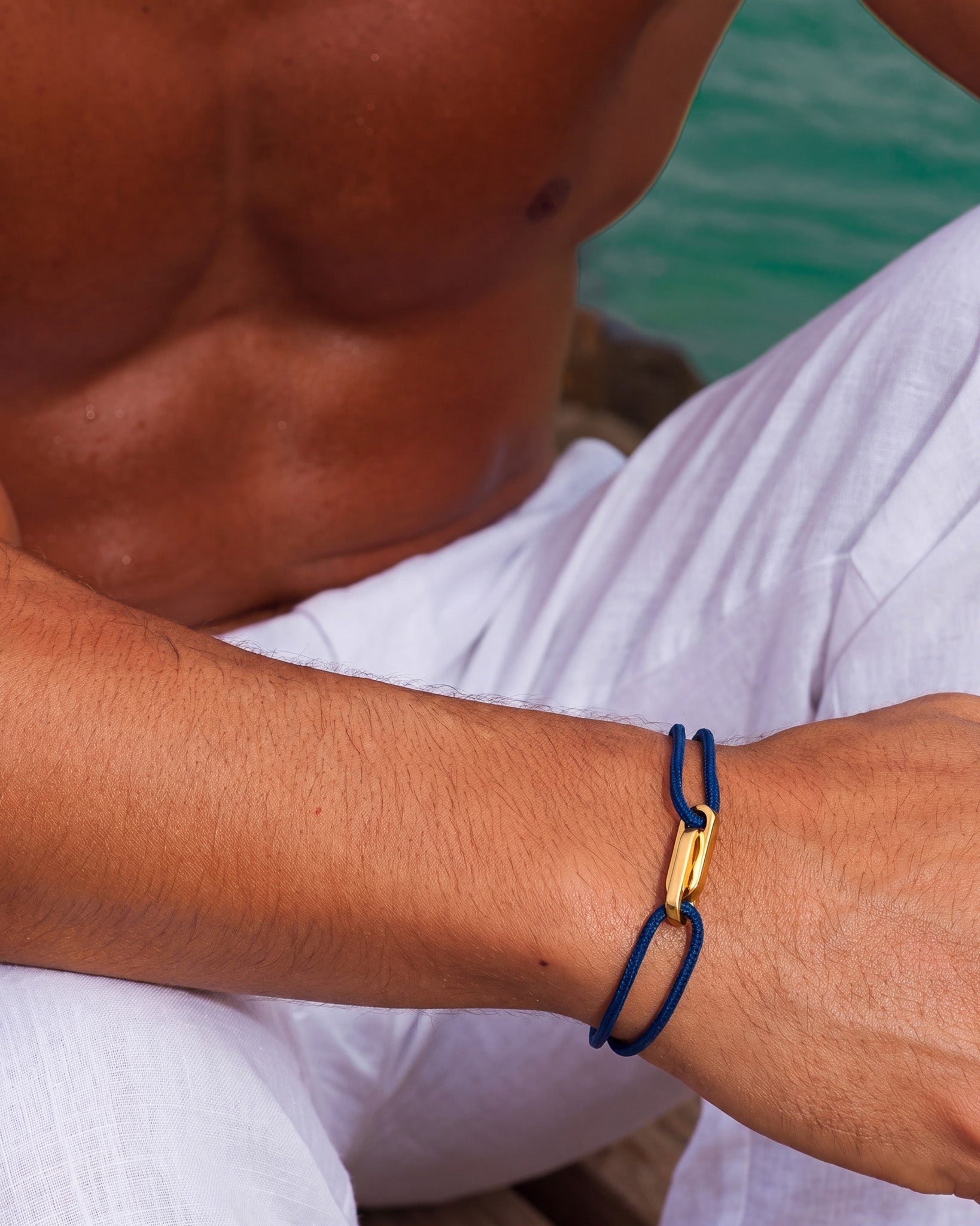 Atlantis Gold Bracelet with blue cord and gold clasp worn on the wrist