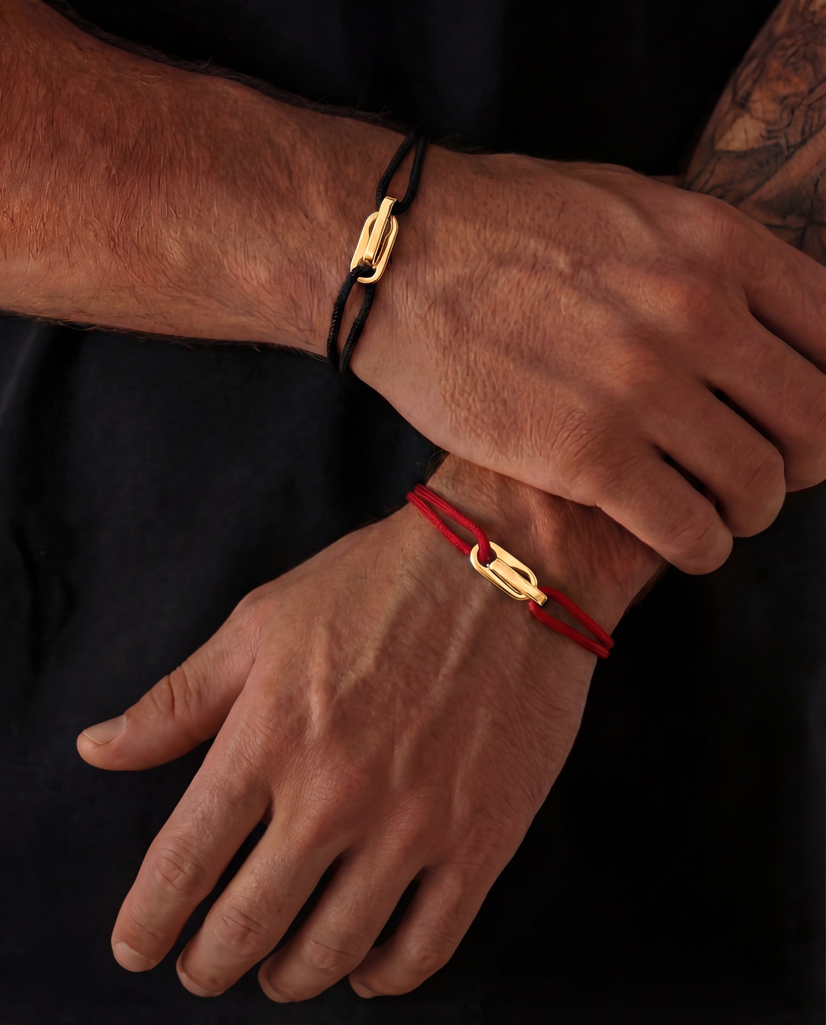 Atlantis gold bracelet with a black adjustable cord worn on the wrist