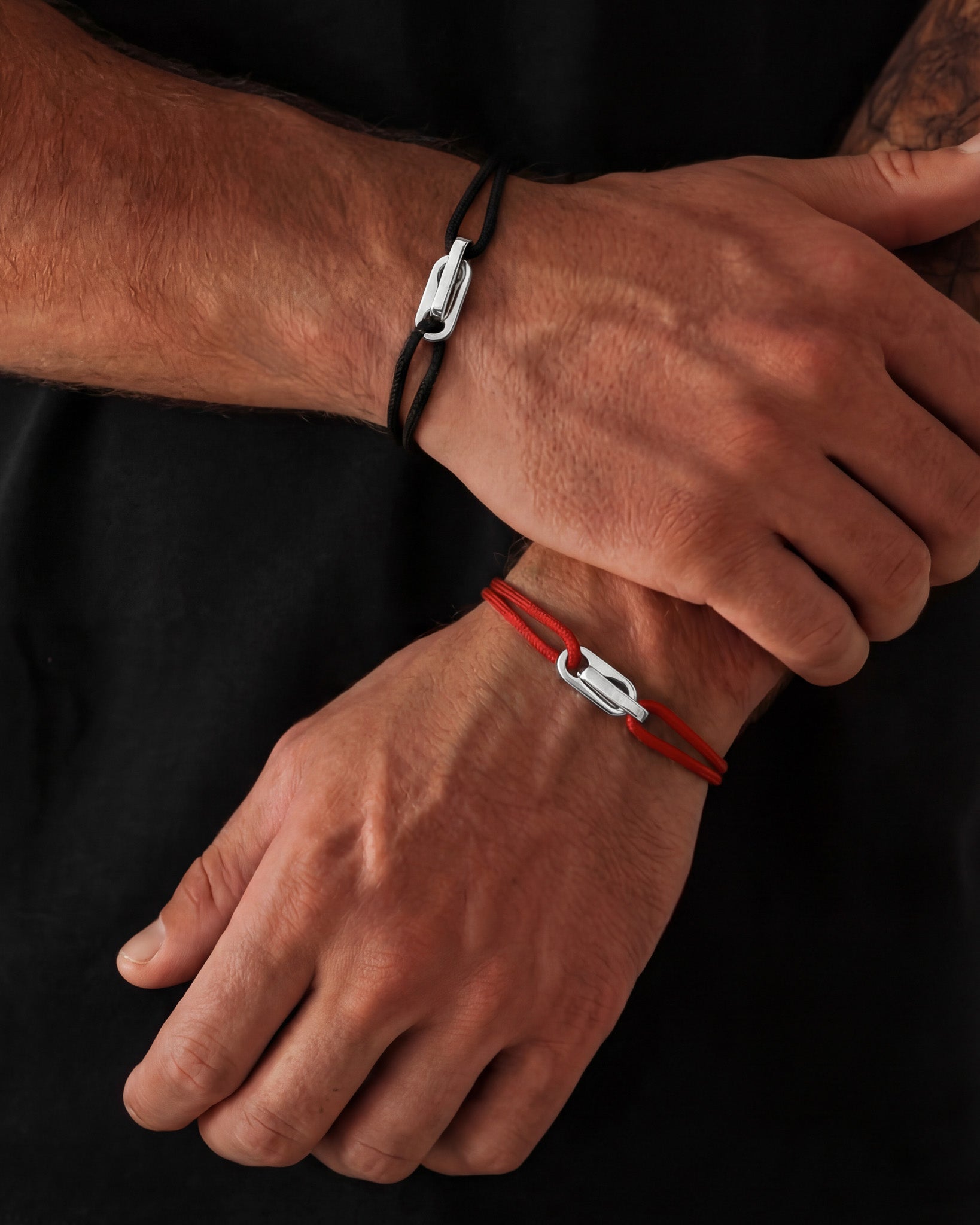 Atlantis bracelet on the wrist with black cord and silver clasp
