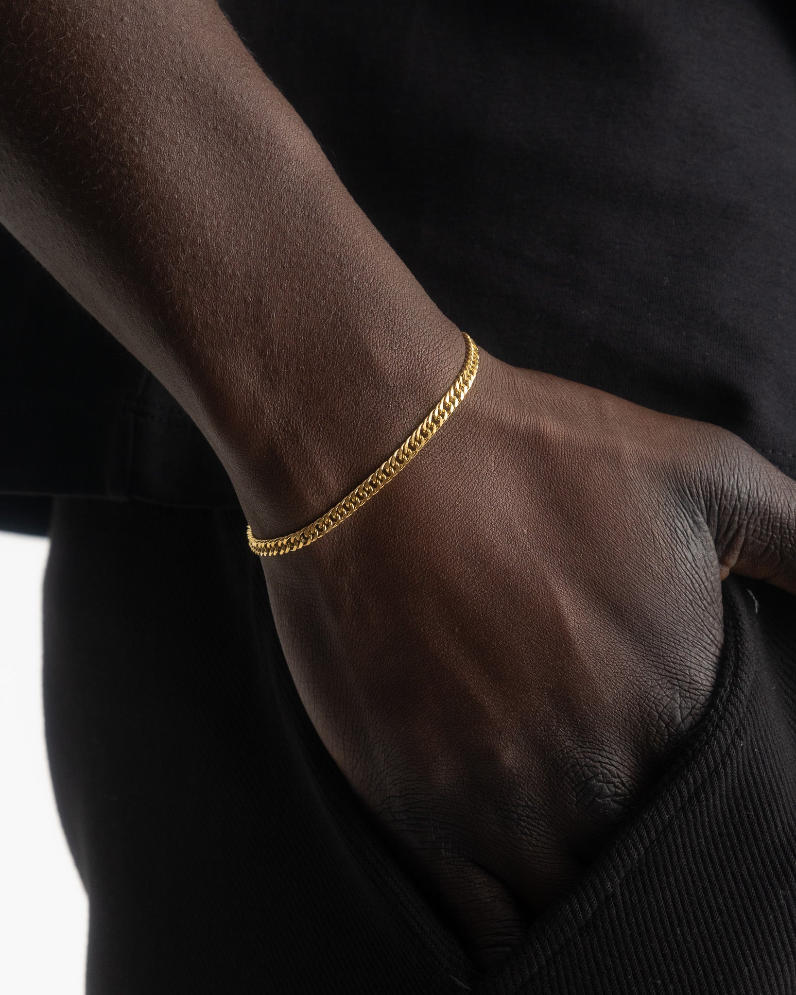 Gold coral chain bracelet wrapped around a wrist in a close up shot