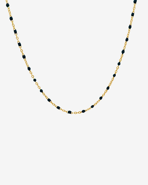 Gold chain necklace with evenly spaced black beads, 50 cm long, on a white background.