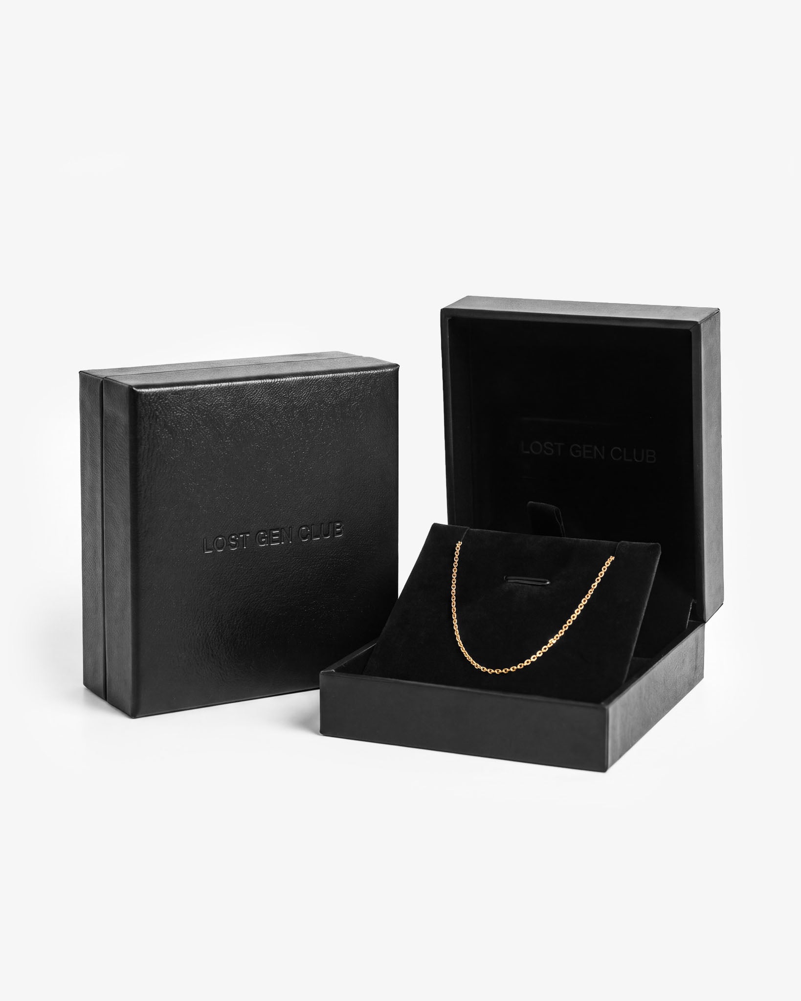 Black premium gift box shown closed and open, with LOST GEN CLUB embossed on the lid and a gold chain on the velvet insert