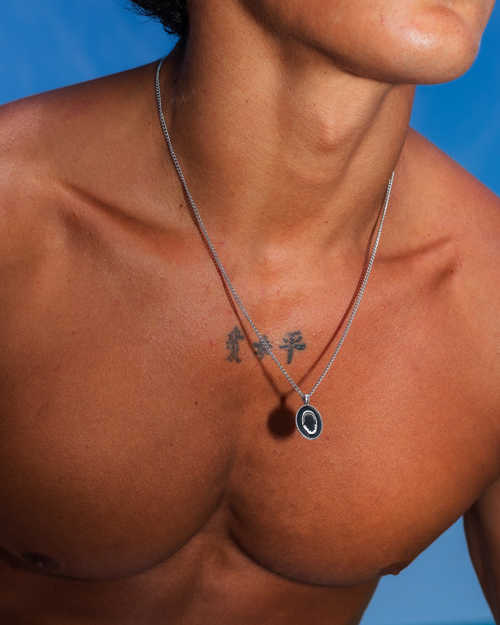 Close-up of the Lombok silver necklace around the neck with a round pendant