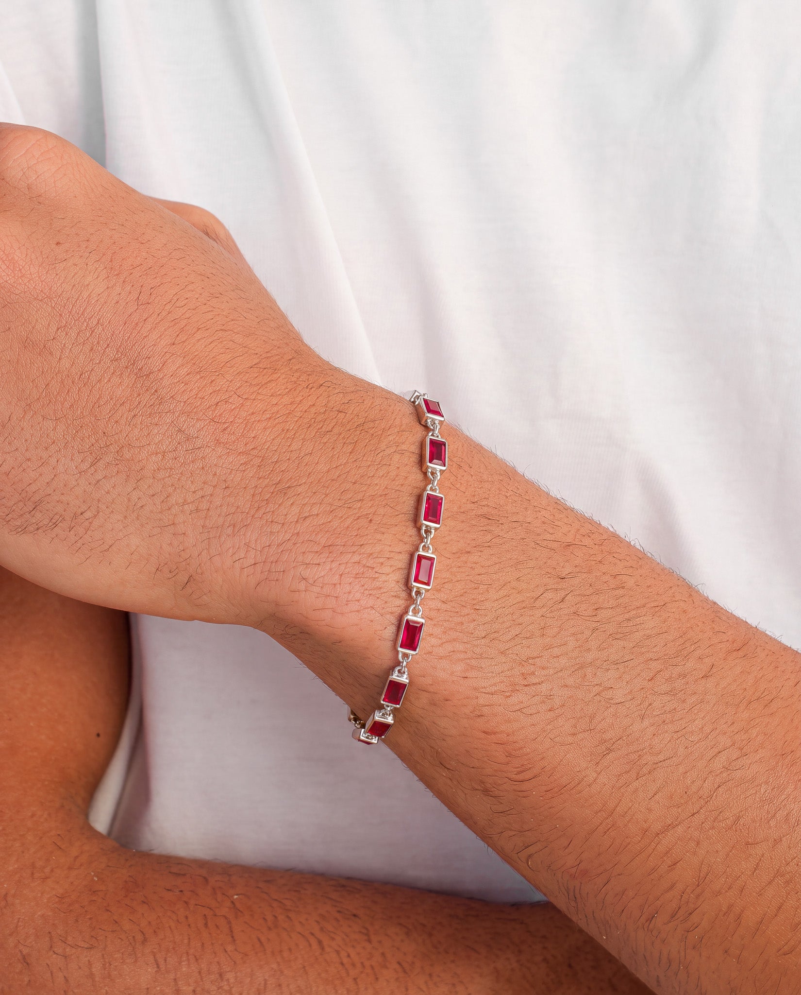 Omen silver bracelet with red rectangular stones worn on the wrist