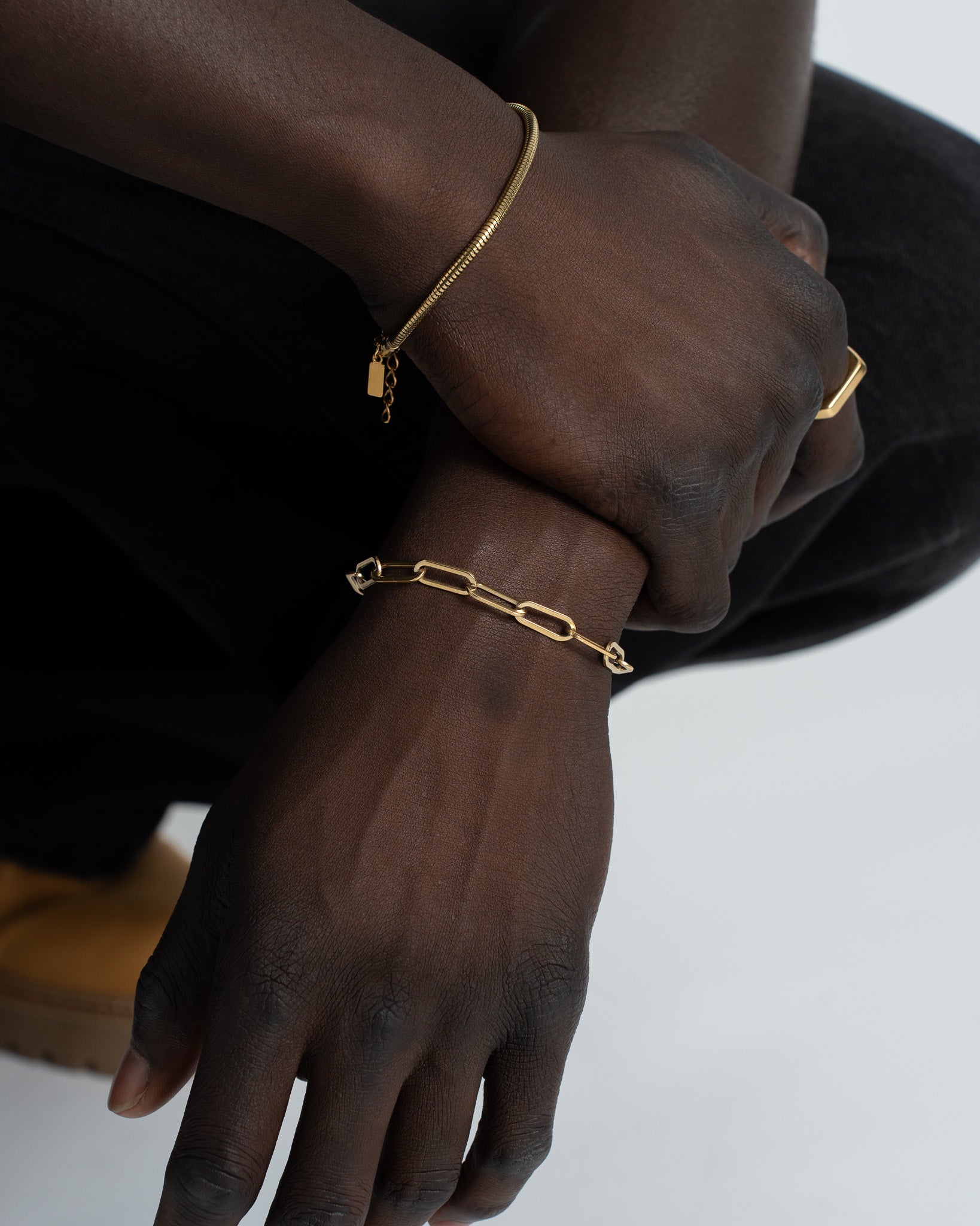 Egyptian inspired gold bracelet worn on dark skin wrist with adjustable length and a small rectangular charm