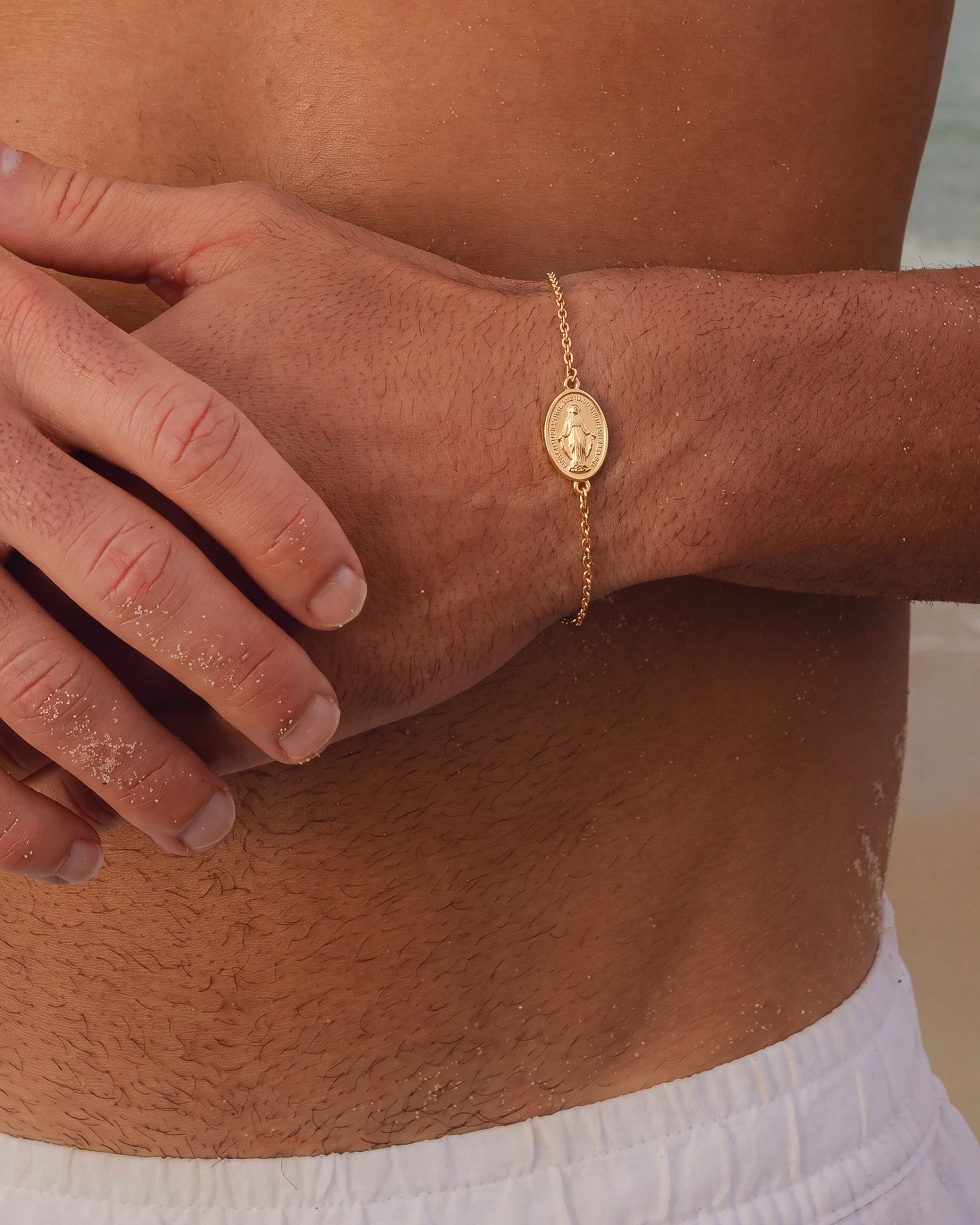 Wrist view of the gold Virgin Mary bracelet with oval medallion.