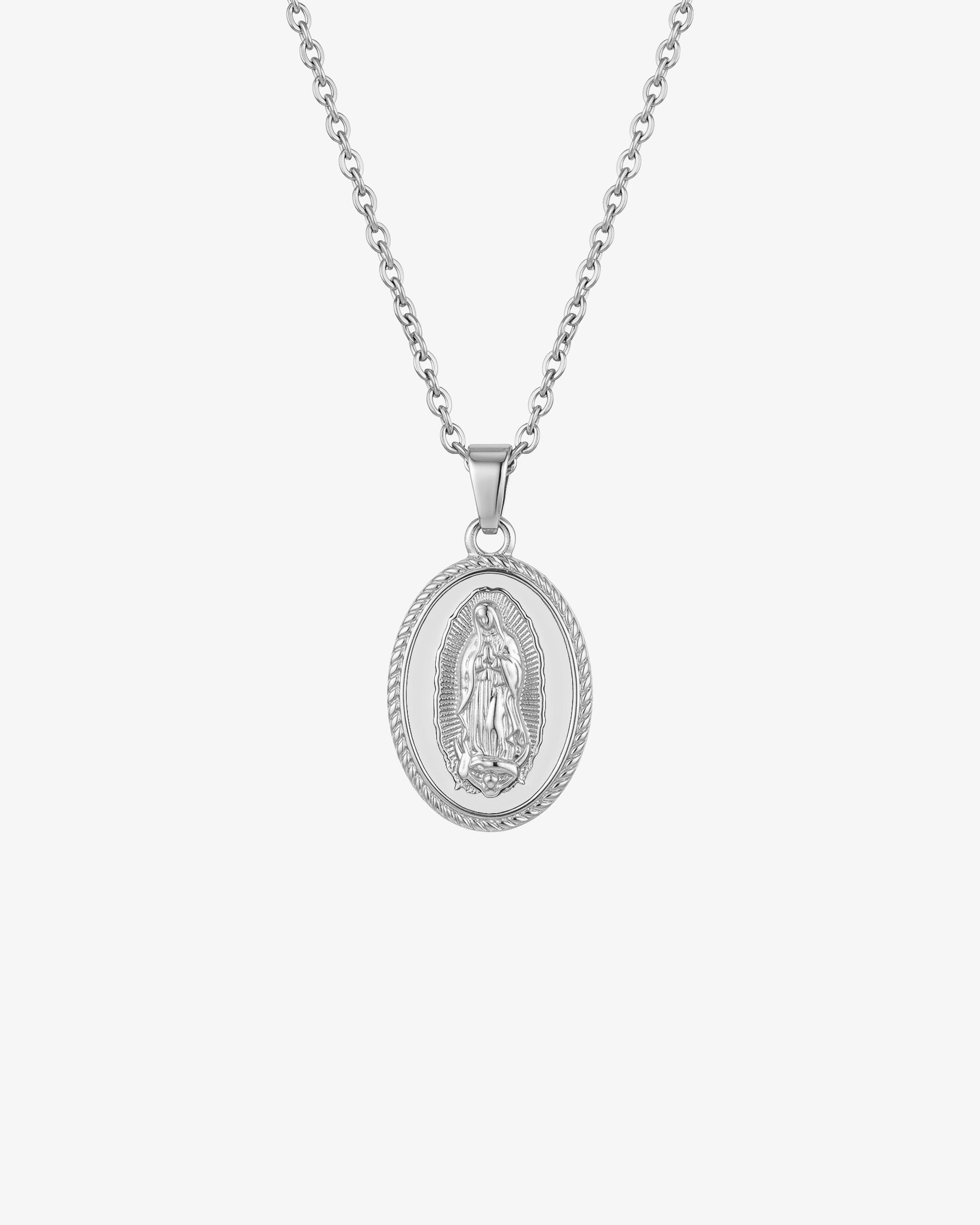 Silver chain necklace with an oval Virgin Mary pendant on white enamel background.