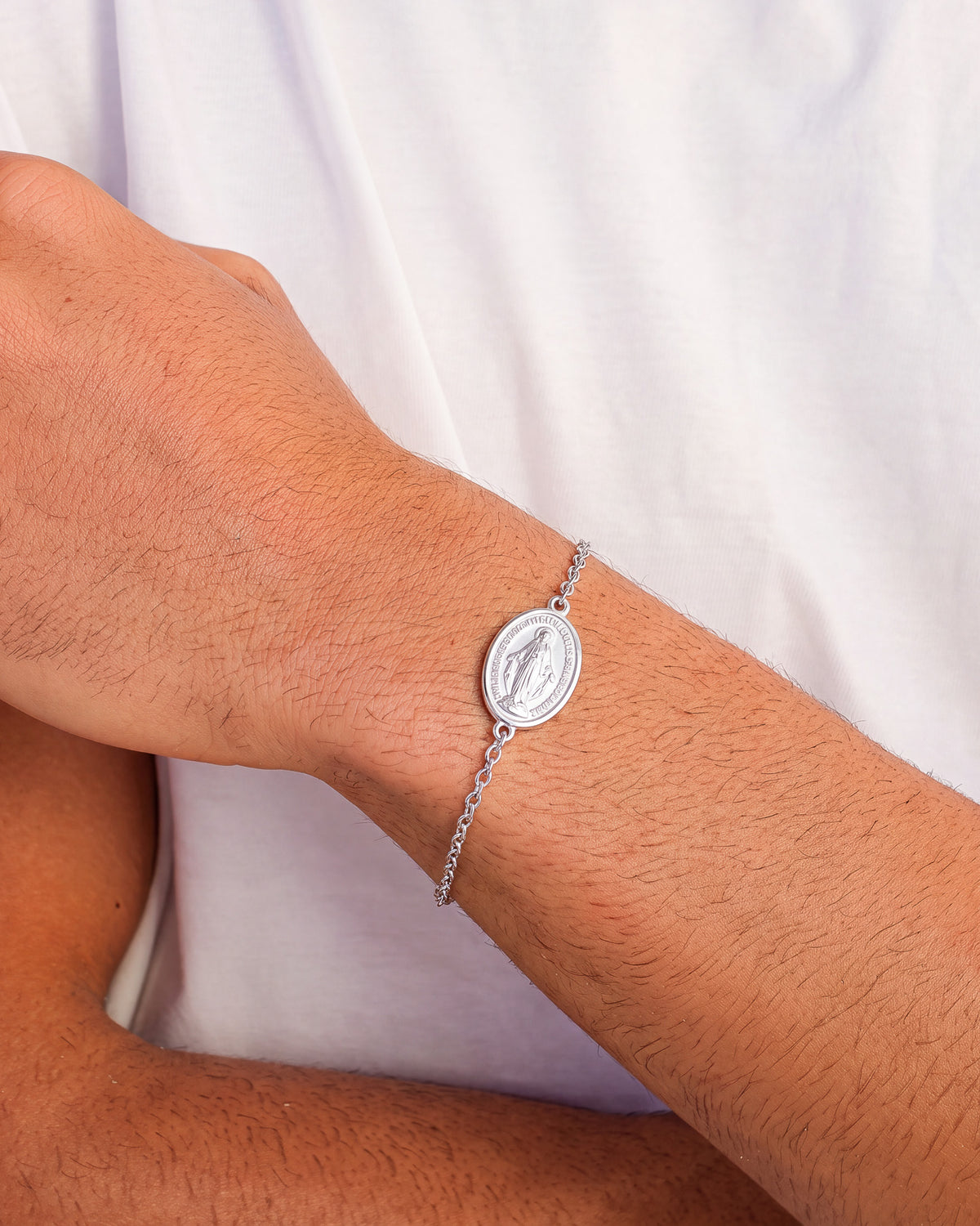 Silver Virgin Mary bracelet worn on the wrist with a round medallion charm.