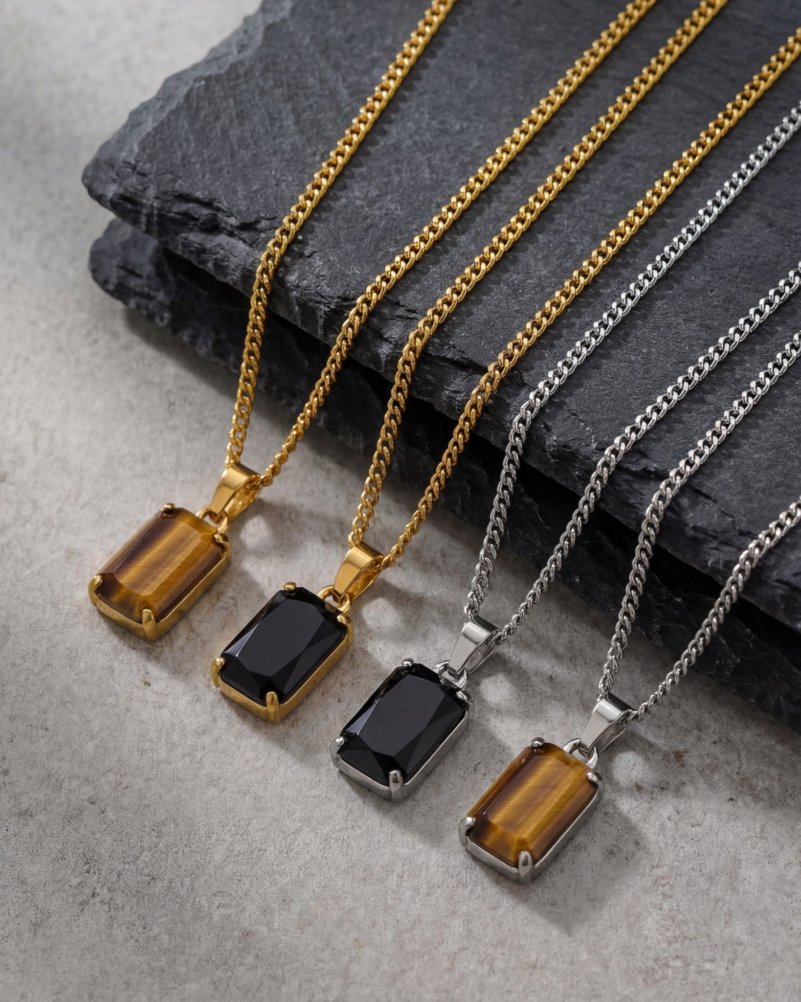 Gold tone Volt necklace with a rectangular amber stone pendant on a dark stone background